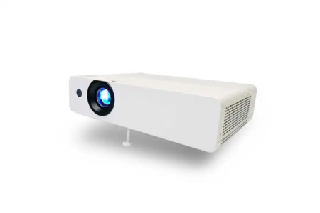Image shows a white projector with a simple design. Has a big lens on the front with blue light coming out, it’s on. Ventilation grills on the side for cooling. Small adjustable screw foot at the bottom to keep it stable and aligned. Perfect for home entertainment, office presentations and education. Clean and modern design, high quality visuals.