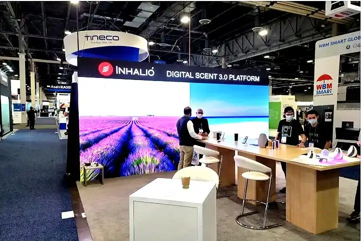 Inhalio’s trade show booth for Digital Scent 3.0. AVR Expos LED Screen rental. A lavender field and beach scene. People chatting at the counter with demo units. Other booths and people in the background. A trade show where we provided many AV rentals for exhibitors. If you are looking for audio visual rental in Las Vegas we have you covered.