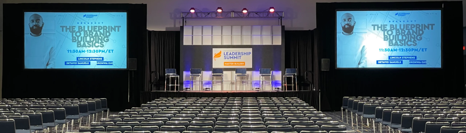 Indoor event setup in Atlanta with audio visual equipment, including cameras, screens, lighting, and staging for a professional presentation