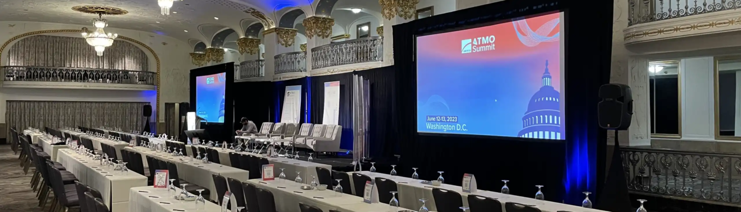 Indoor event setup in Atlanta with audio visual equipment, including cameras, screens, lighting, and staging for a professional presentation