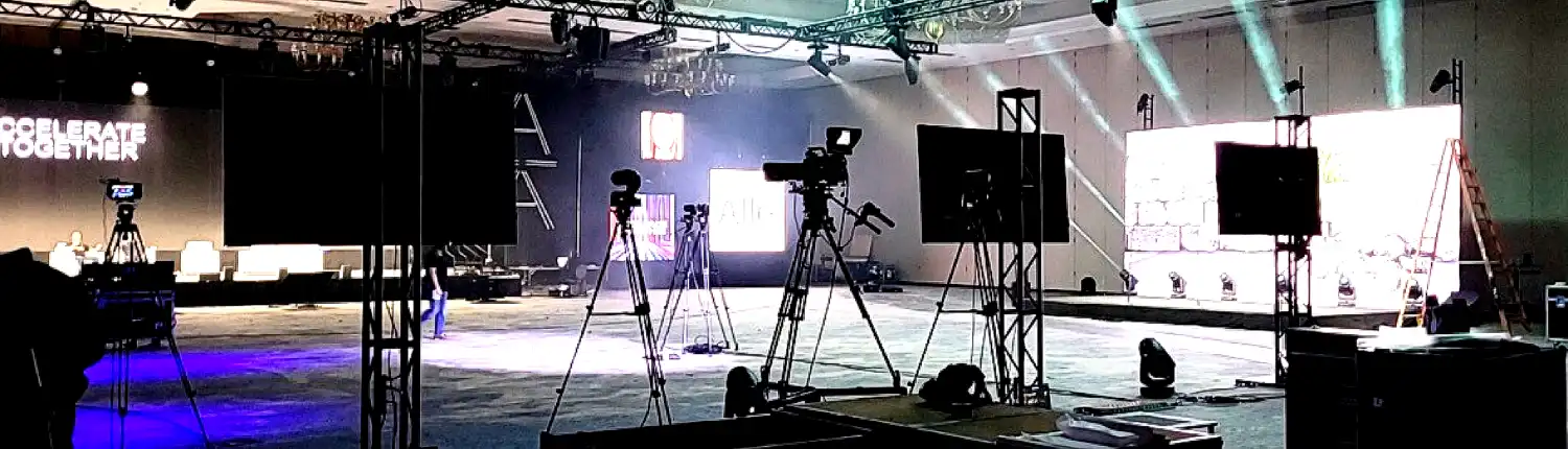 Indoor event setup in Atlanta with audio visual equipment, including cameras, screens, lighting, and staging for a professional presentation