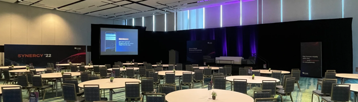 Indoor event setup in Atlanta with audio visual equipment, including cameras, screens, lighting, and staging for a professional presentation