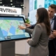 Attendees using an interactive touchscreen kiosk at an event powered by AVR Expos.